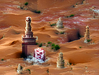 An ornate marble tower emerging from a desert of red sand.png