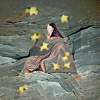 Woman cloaked in stars on a cliff.png